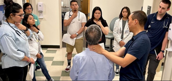 Photo of group of medical students learning in a clinical demonstration with a patient at UC Davis Health.