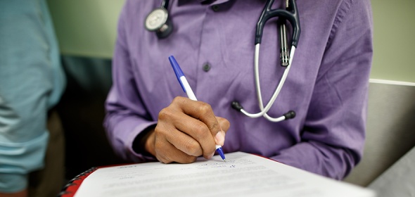 Photo of hand with pen on a medical record