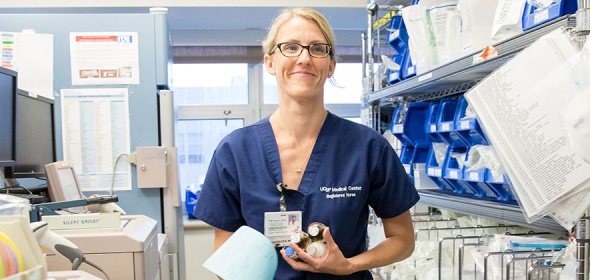 A registered nurse at UCSF Medical Center holds medications in a nursing station.