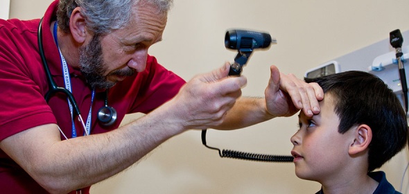 A primary care provider performing an assessment on a young patient.