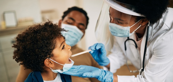 BIPOC physician providing a check up for a BIPOC child with BIPOC mother in the background. 