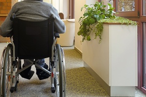 Photo of a frail person in a wheelchair in a long term living facility.