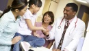 Stock photo of clinicians with mother and child in a medical office.