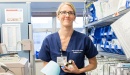 A registered nurse at UCSF Medical Center holds medications in a nursing station.