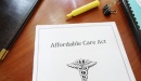  A stack of documents with the top sheet that reads: "Affordable Care Act".